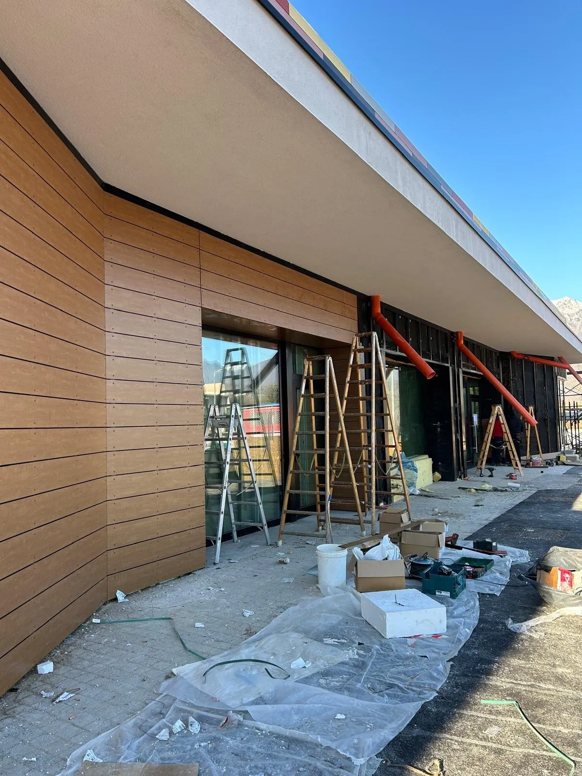 Posa di rivestimento di facciata effetto legno su un edificio commerciale